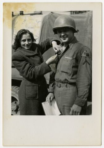 A Czech Girl Pins Something Onto The Uniform Of An American