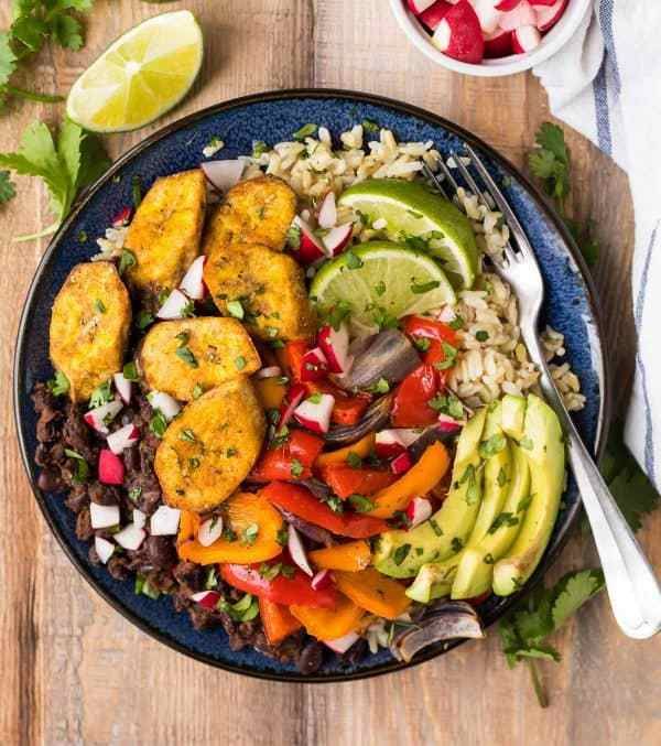 Nourishing Cuban Black Beans and Rice Bowls with baked plantains (tostones), roasted vegetables, and avocado. Packed with authentic Cuban flavors and ingredients. A healthy, filling, all-in-one recipe that’s vegan and gluten free! #cubanrice