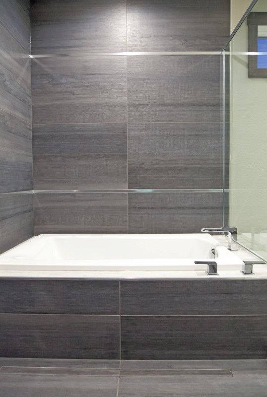 Stacked ceramic tiles giving this bathtub a layered stone look. Tub