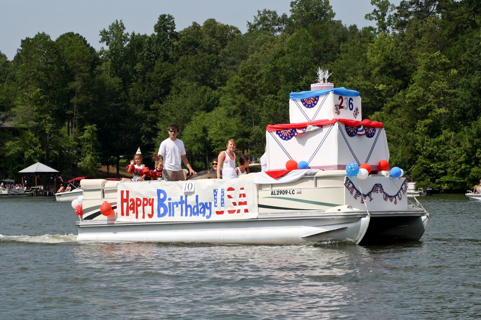 People Are Riding On The Back Of A Boat With A Happy Birthday Sign blanket-fort-sleepover-architects-slumber-party-glamping-tent