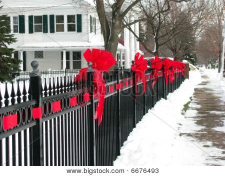 Red Ribbon Bows On The Iron Fence Along A Small Town Street Red Ribbon Bows On The Iron Fence along a Small Town Street - Red Ribbon Bows On The Iron Fence Along A Small Town Street