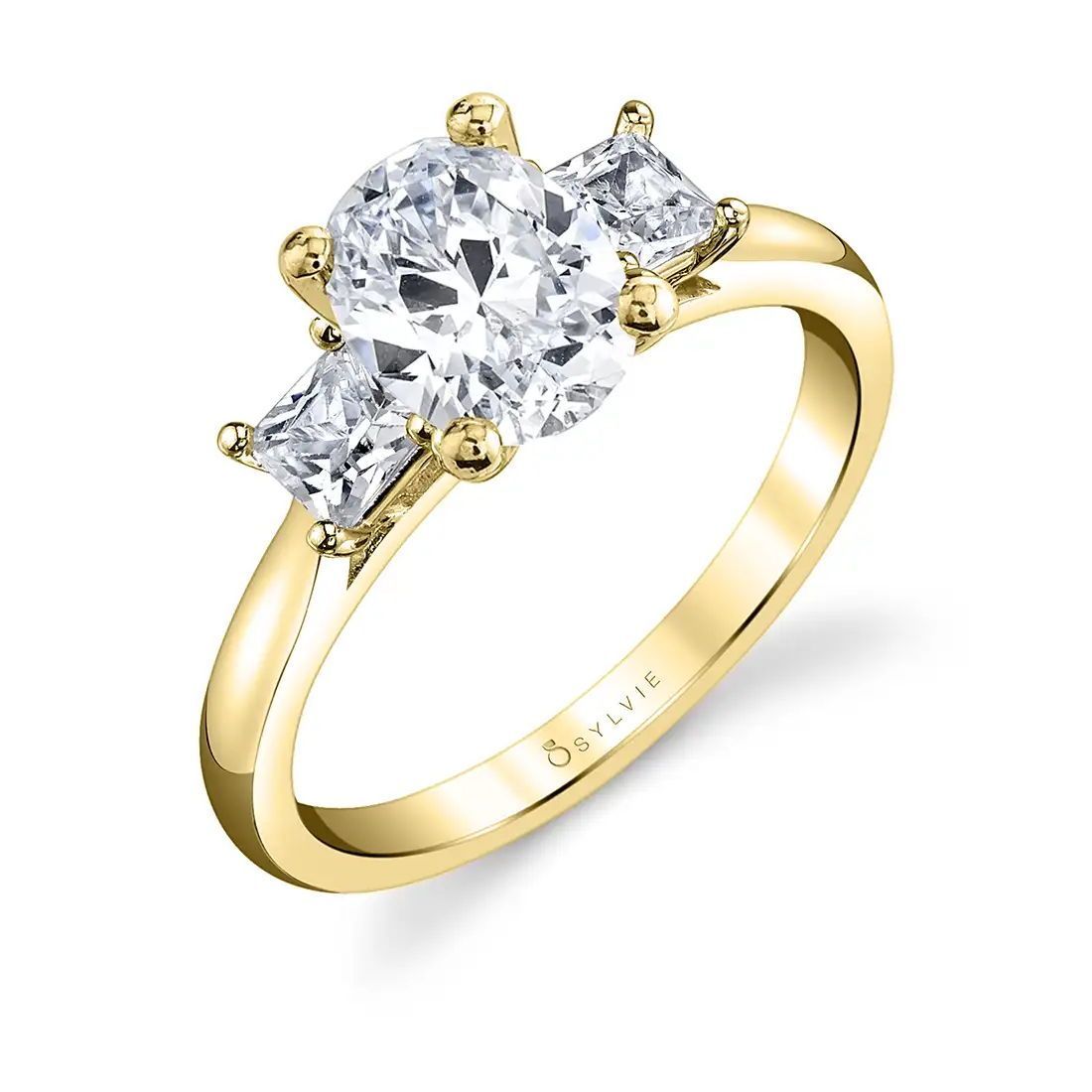 This stunning modern 3 stone oval engagement ring features a 1 carat oval cut center diamond surrounded by two shimmering princess cut stones on each side for a total carat weight of 0.46. The diamonds are all set on a modern high polish shank for a chic and practical look that will never go out of style. Modern Three Stone Oval Engagement Ring | 1 Carat Center Diamond Engagement Rings | Sylvie Collection Sylvie Engagement Rings, Yellow Gold Engagement Rings, Three Stone Engagement Rings, Engagement Ring Styles, Custom Engagement Ring, Three Stone Rings, Designer Engagement Rings, Unique Engagement Rings, Unique Rings