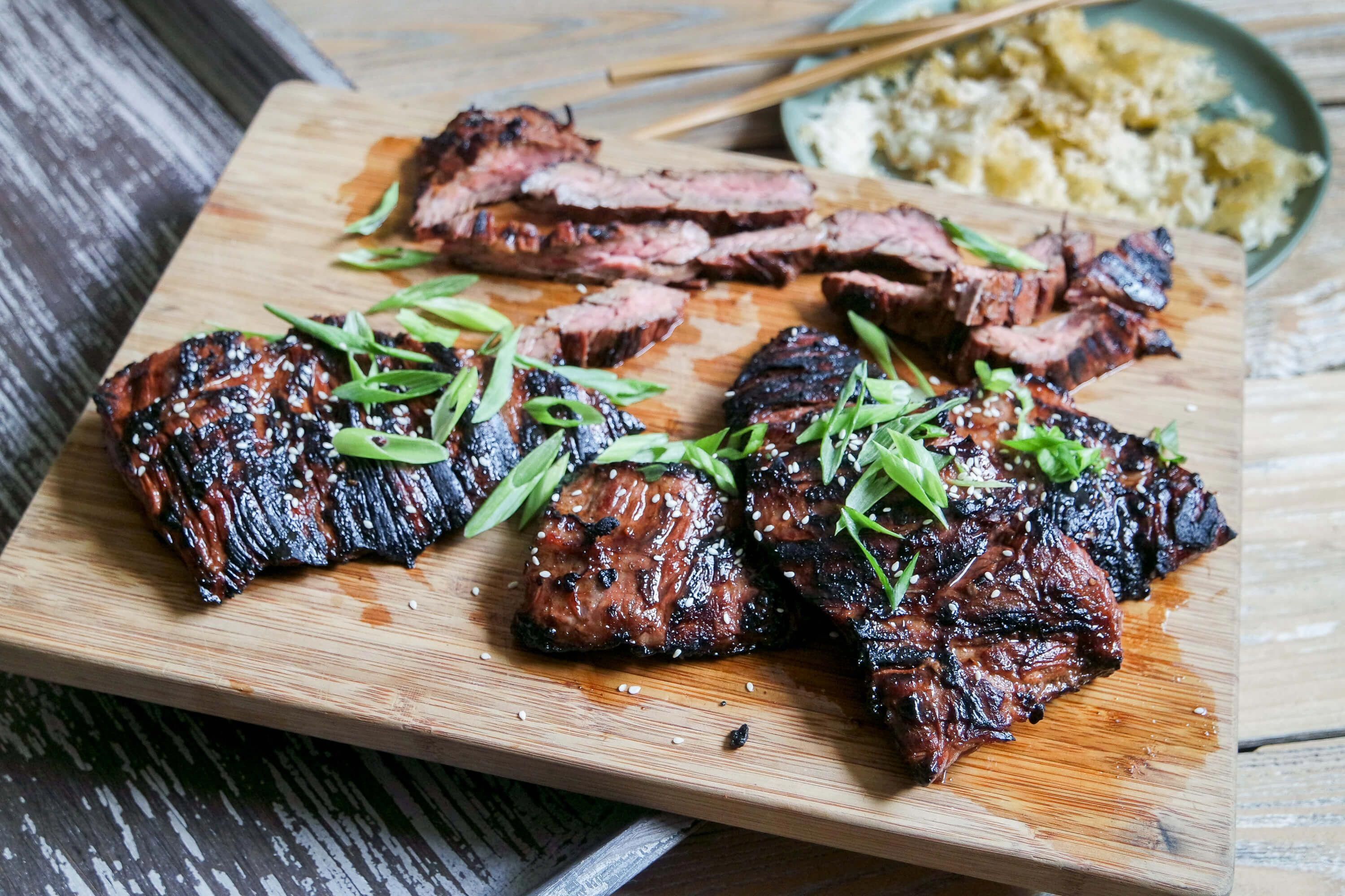 A soy and sriracha marinade lends a salty, umami punch with a hint of sweetness. Paired with crispy rice, this Asian Marinated Grilled Skirt Steak is hard to beat. #grilledsteak #marinadeforskirtsteak