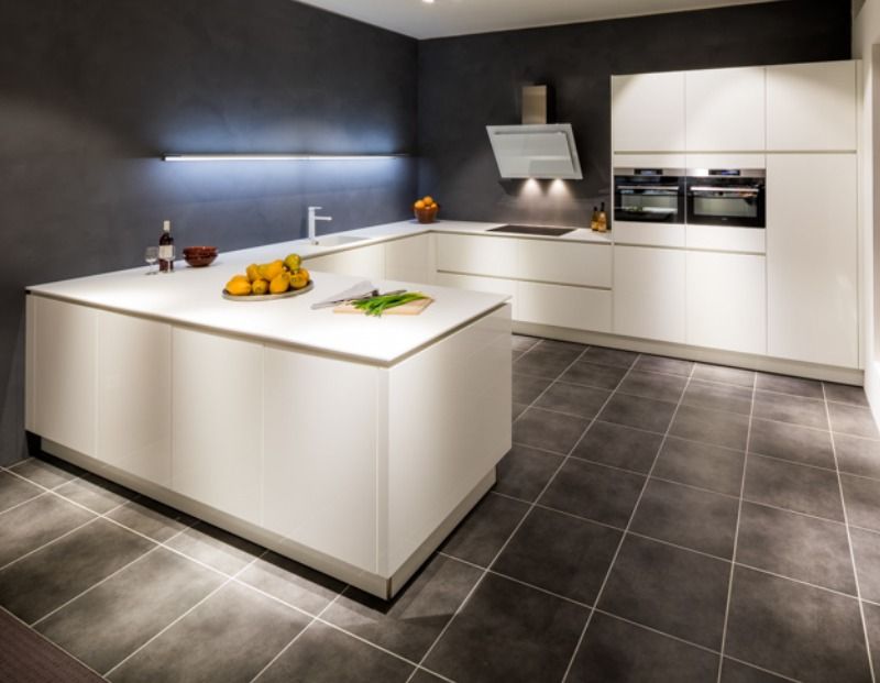 Een compleet witte keuken met witte greeplijsten en witte ...