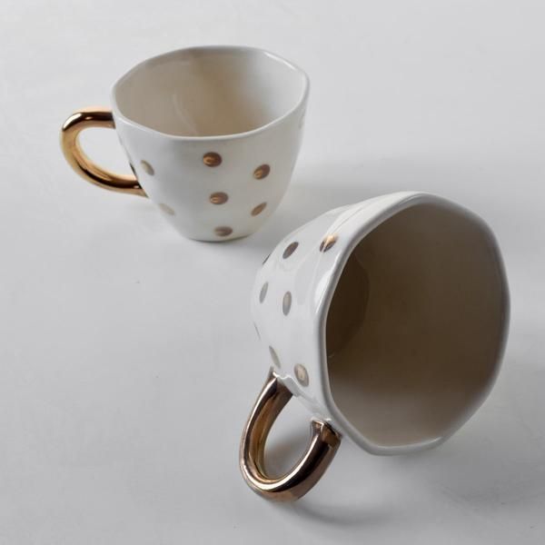 Esmira Golden Polka Dot Ceramic Cup with Golden Handle With a classic polka dot design and a stunning combination of ivory and gold, our Esmira cups will enhance the splendour of your favorite brew. The cup's surface is deliberately uneven, making each piece one-of-a-kind, and he golden handle adds a lustrous flourish to this piece. Ceramic Cups, Glazed Ceramic, Polka Dot Design, Polka Dots, Gold Color Palettes, Flourish, Lustrous, Design Details, Handmade Natural