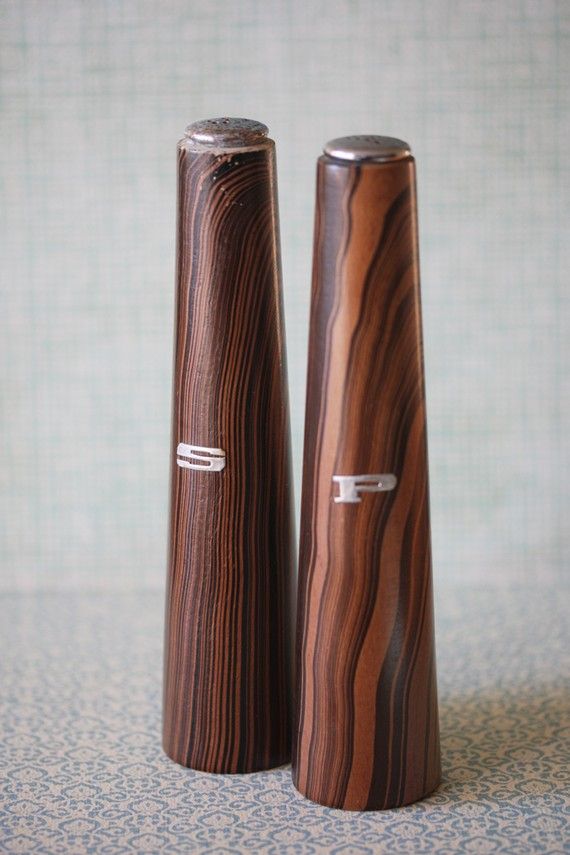 mid-century wood and metal salt and pepper shakers on a stand