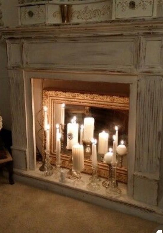 Candles reflected on mirror in fireplace. So romantic! Faux fireplace