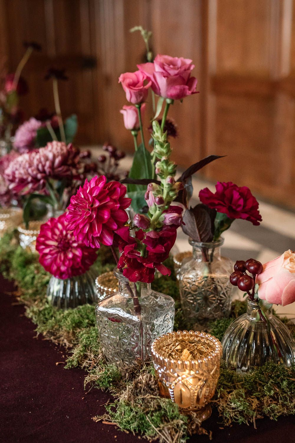 Winter Luxe Wedding Ideas With Red Velvet A Fireplace Flower Bottle Flowers Table Centrepiece Decor Red Pink Moss Gold Dahlia Rose Winter Luxe Wedding Ideas Becky