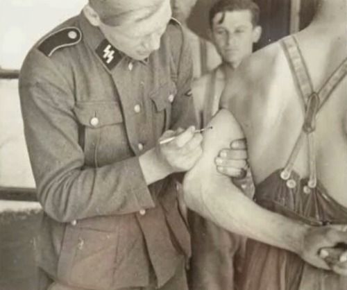 ss officer getting a blood group tattoo on his underarm ww2 the
