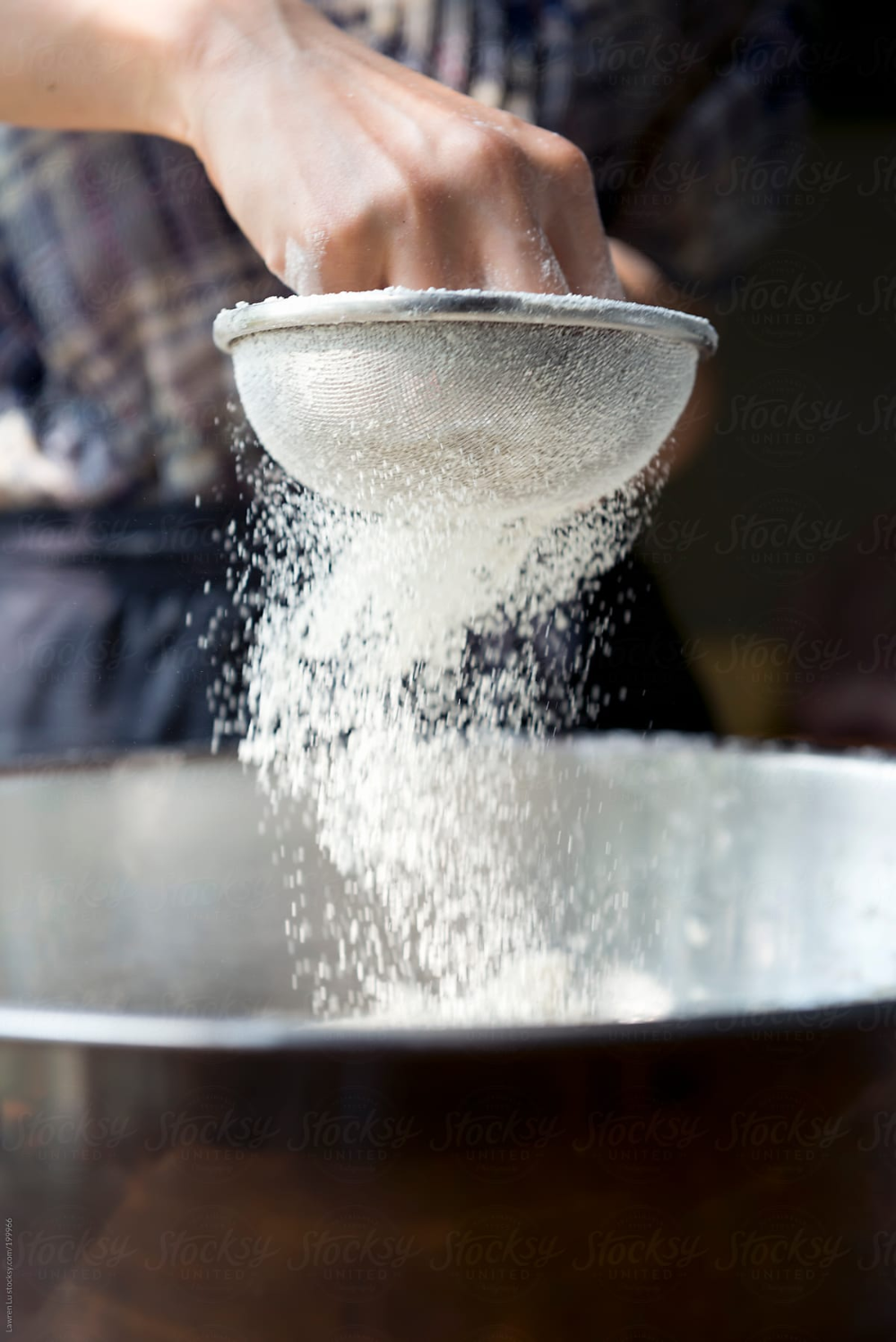 Young Woman Hands Sifting Flour For Baking by Stocksy Contributor Lawren Lu