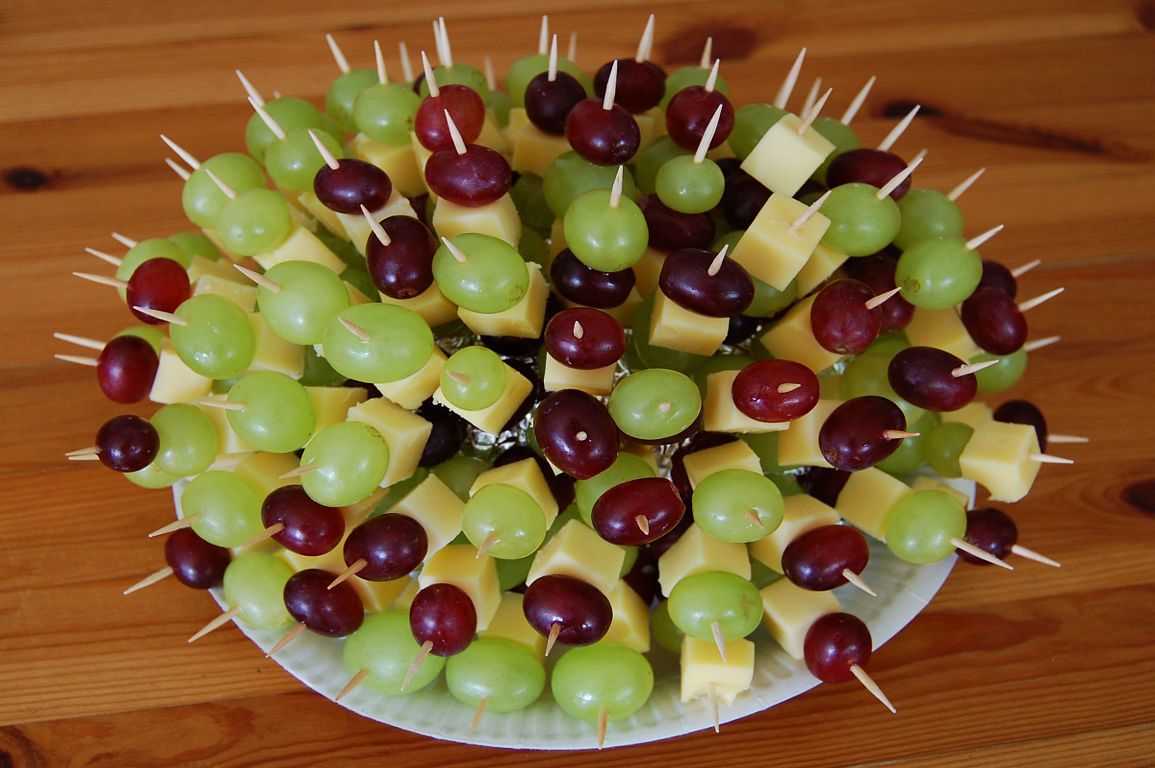 grapes and cheese are arranged on skewers with toothpicks in the middle