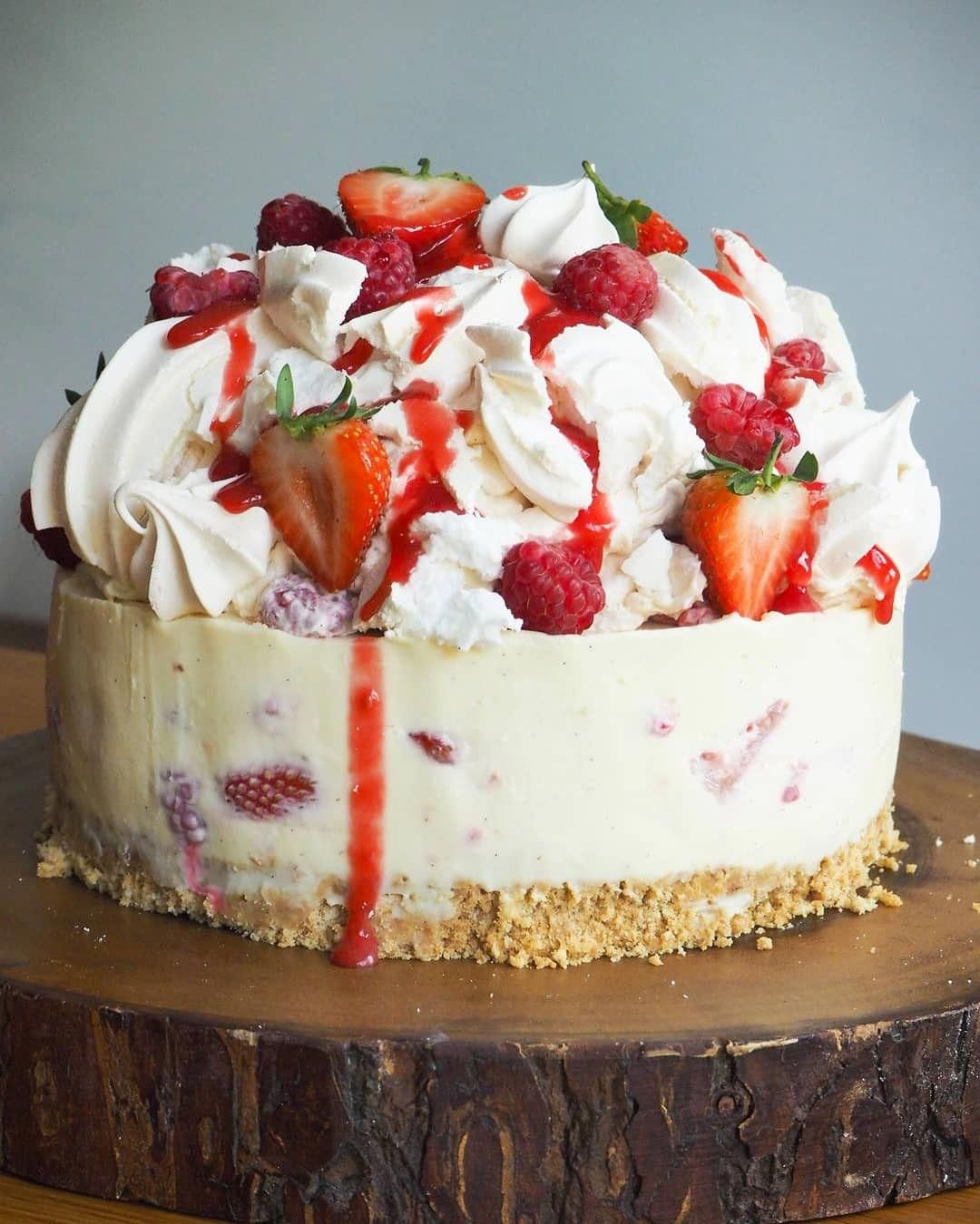 White Chocolate Cheesecake folded with Strawberries & Raspberries on a classic digestive base. Topped with a mountain of eton mess; crush meringues, fresh meringues and fresh berries #chocolatecheesecake #whitechocolateraspberrycheesecake
