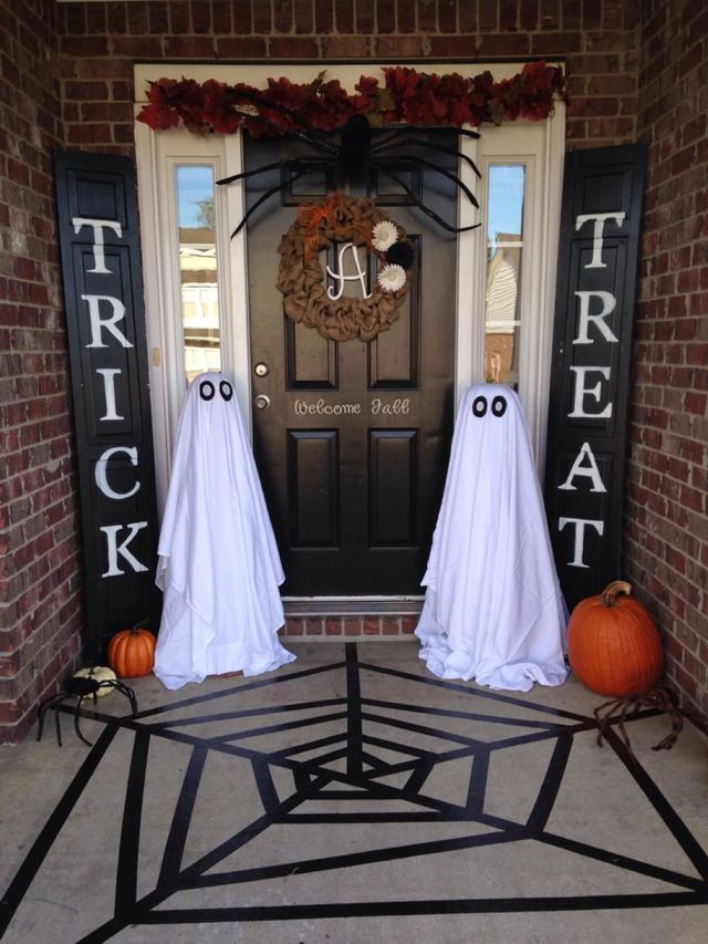 two halloween decorations on the front door of a house with ghost faces ...