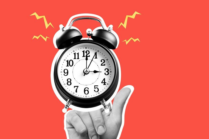 Human hand holding alarm clock on red background, idea concept