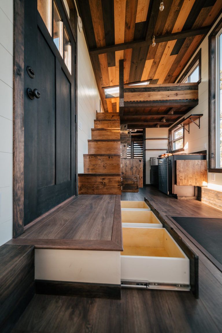 The Silhouette: 26ft Tiny House on Wheels with Large Windows and a Built-in Gym! #tinyhome Such practical storage ideas - the floor/step drawers, under stairs cabinets, and fold down counter <3 #tinyhousestorage