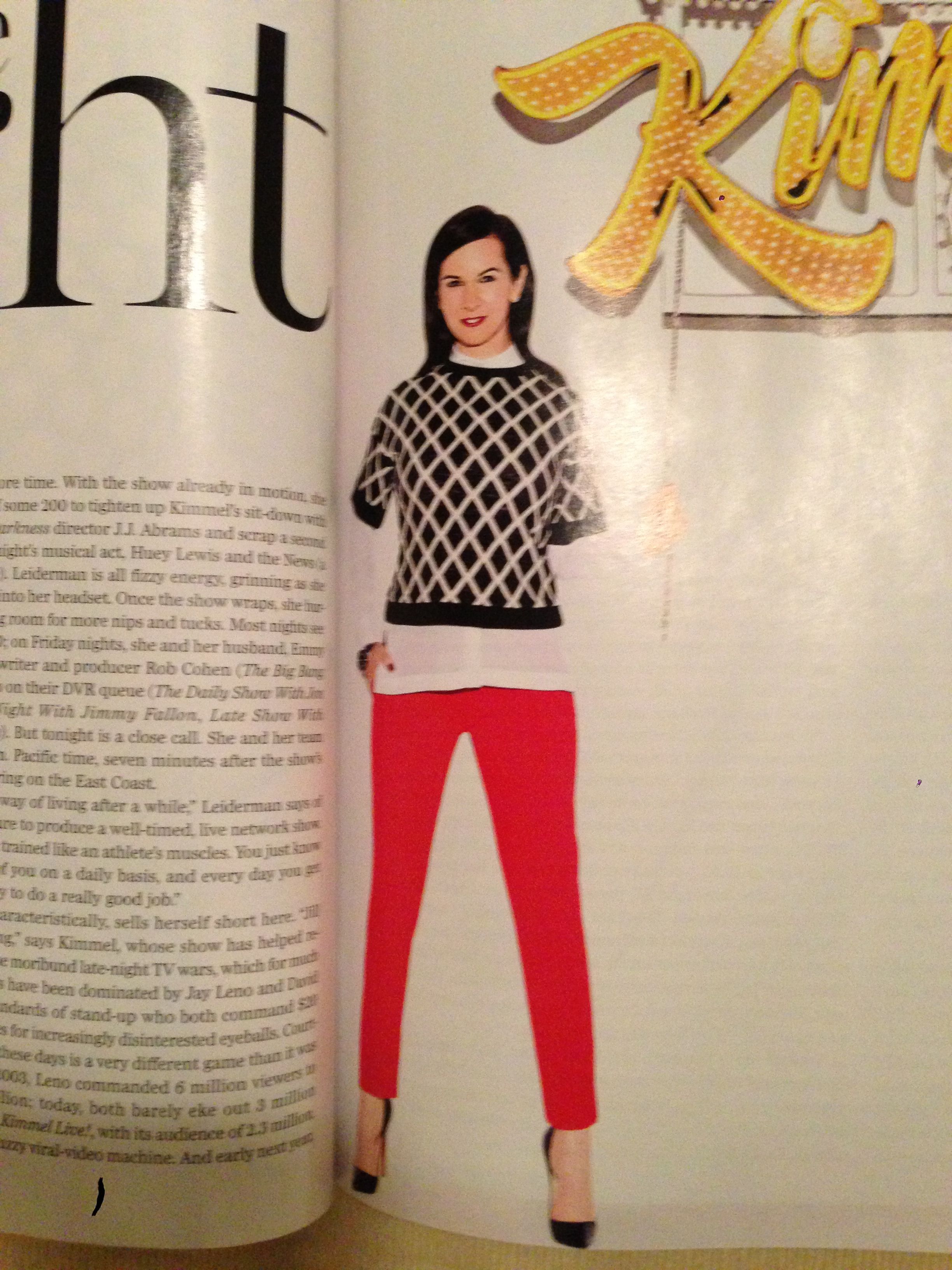 Black and white patterned sweater over a white button down; red pants