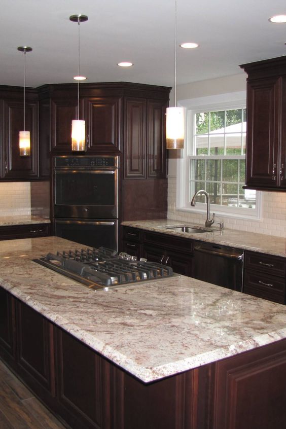 a dark stained kitchen with white and brown granite countertops and a white tile backsplash that refresh this dark and chic space Dark Brown Cabinets, Dark Kitchen Cabinets, Kitchen Cabinet Storage, Kitchen Redo, Home Decor Kitchen, Home Kitchens, Kitchen Design, Kitchen Ideas With Brown Cabinets, Dark Brown Kitchen Ideas