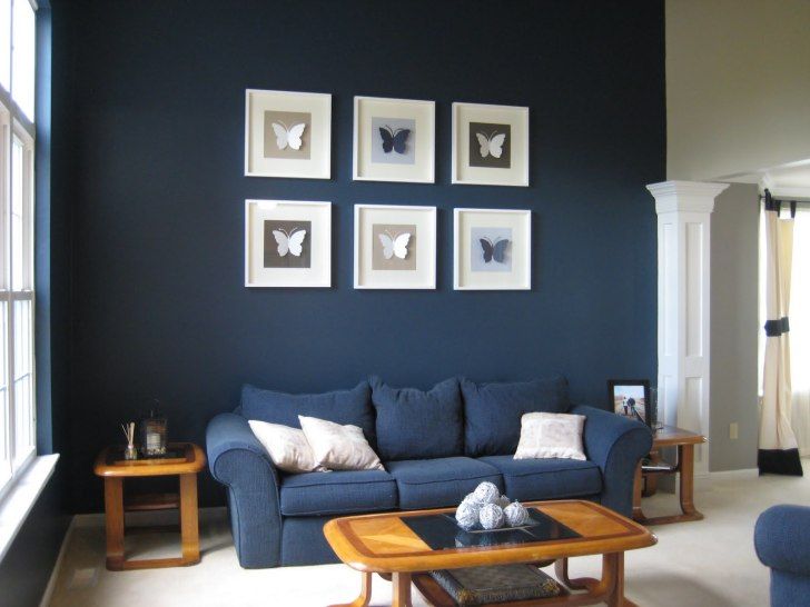 Blue Fabric Sofa With White Cushions Between Brown Wooden Side Table And Rectangle Brown Wooden Table Blue Walls Living Room Living Room Paint Blue Sofa Living