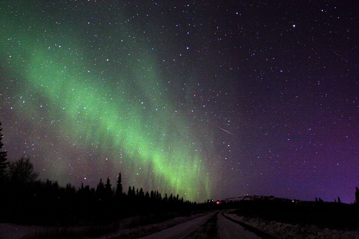 an image of the night sky with green and purple aurora bores in the