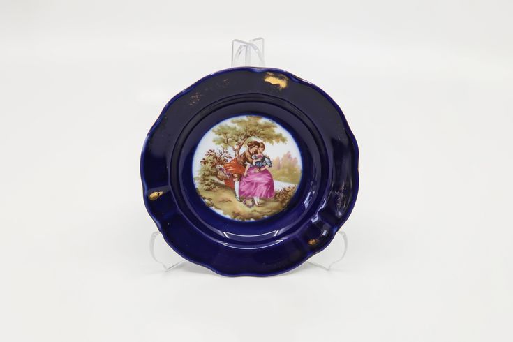 Yuvarlak Formlu, Beyaz Renk Üzeri El Boyası Kobalt Mavisi Renkli Porselendir. Kenarı ve İçi Altın Yaldız Desenlidir. Tabanına Fragonard Deseni Resmedilmiştir. Kullanılmış, 2.El Vitrin Ürünüdür. Limoges
