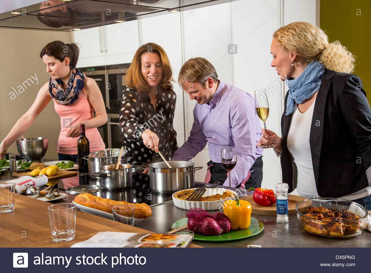Friends Cooking Together In A Kitchen Preparing A Meal Together