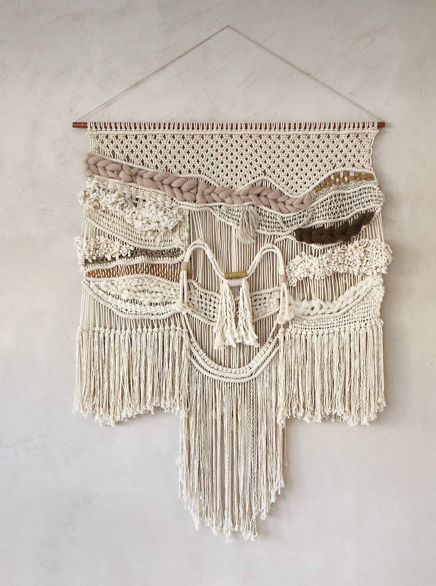 macrame wall hanging with crochet and tassels on white background