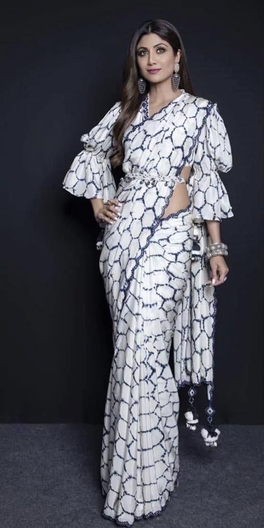 Feeling the gloom so deep and are you on the lookout for kicking them out? If fashion occupies a massive spot in your heart, you should try picking out outfits that scream drama. Maybe that’s the pick-me-up your mood is craving for. To cite an example, sarees need no shoutouts for they’ve won many titles of being elegant. And, if sarees aren’t your most preferred choice anymore, you can always explore in terms of maxi skirts, gowns, or pants, anything that entices you the most. But, how you styl Trendy Sarees, Stylish Sarees, Fancy Sarees, Stylish Dresses, Designer Saree Blouse Patterns, Saree Blouse Designs, Sari Blouse, Blouse Outfit, Long Blouse