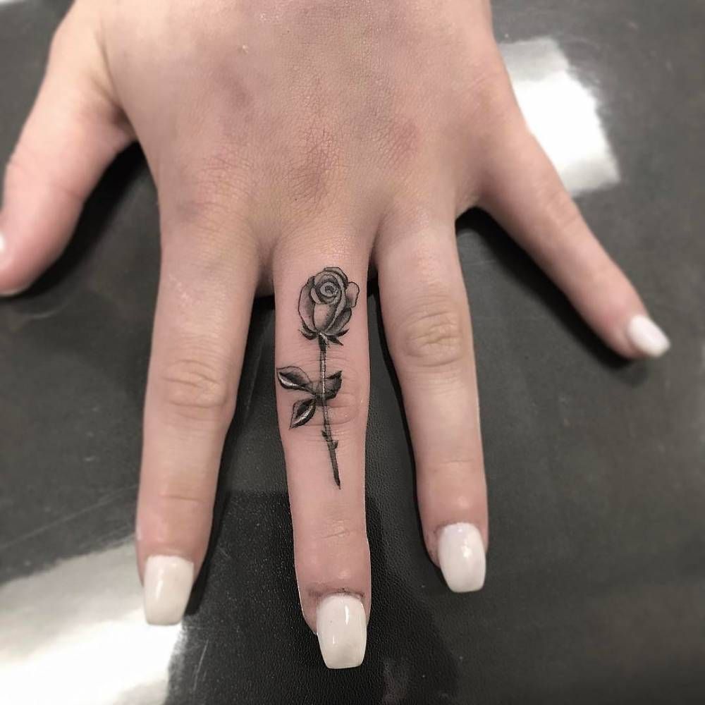 Fine line rose tattoo on the middle finger. Tattoo Artist