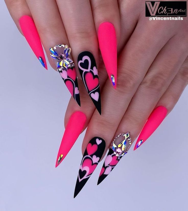 Fans of long acrylic nails will love these black and pink extra-long stiletto nails. These nails not only feature stunning heart designs, but they also stand out by including amazing rhinestone embellishments. Stiletto Nail Art, Bling Acrylic Nails, Pretty Acrylic Nails, Bling Nails, Best Acrylic Nails, Swag Nails, Pastel Nails, Grunge Nails, Acrylic Art