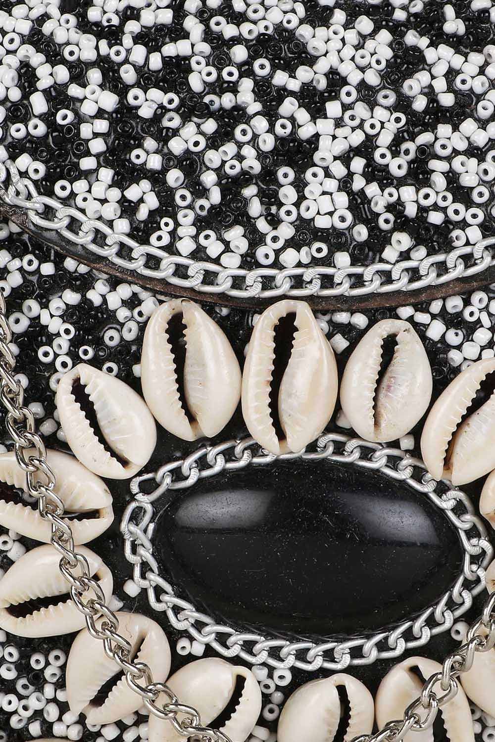This White & Black Box Clutch comes with a spacious main compartment secured with a Click closure. It features a Shell Embellished Pattern on fabric and comes with a Detachable Shoulder strap. Product Features: Color: White & Black Fabric: Metal Pattern: Shell Embellished Style: Shell Embellished Clutch with Click Closure Surface Style: Embellished Strap / Handle: Shoulder strap Strap Adjustable: Non-Adujstable Strap Detachable: Detachable Shape: Halfmoon Care: Wipe with a clean and dry cloth Wa