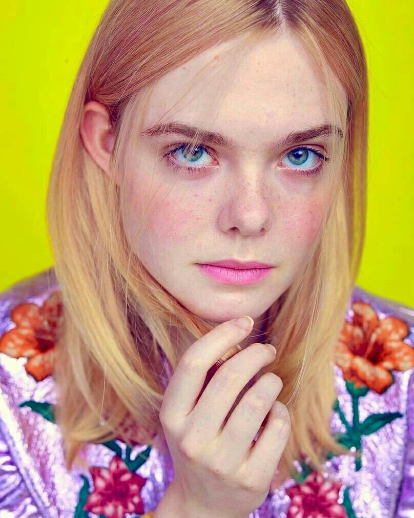 A Woman With Blonde Hair And Blue Eyes Is Posing For A Photo In Front A Woman With Blonde Hair And Blue Eyes Is Posing For A Photo In Front