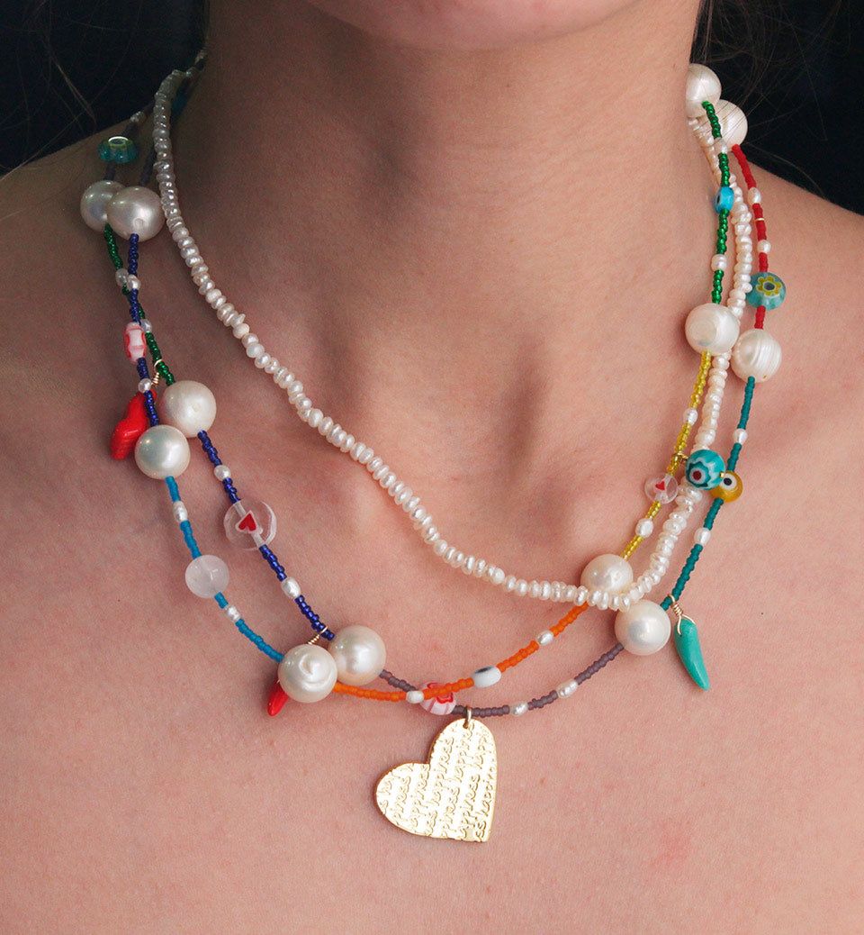 Tres collares en uno, con perlas, chaquiritas de colores, amuletos y un corazón que dice "La Vida es Bella". Hecho a mano por maestros artesanos en nuestro taller en Bogotá, Colombia. Collars, Beaded Necklace, Mercedes, Jewelry, Products, Fashion, Pearl Necklaces, Life Is Beautiful, Bead Necklaces