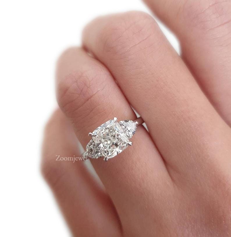 "Classic 2.50CTW Three Stone Cushion Cut Moissanite engagement Ring, White Gold Ring,3 stone Diamond ring, Art deco Ring, Solitaire Ring For Her ►Description of Ring:- ● Center Stone Details: * Center Shape: cushion Cut Moissanite * Center Size: 2.0 CT * Stone Color: Colorless * Stone Clarity: VVS * Mohs Scale : Moissanite 9.25 * Refractive Index : 2.65 (Moissanite) * Total carat weight : 2.50Ctw ● Metal Details:- * Metal Type: Solid Gold * Metal Purity: 14K * Metal Tone: White * Metal Stamp: Ye Oval Diamond Engagement, Cushion Cut Engagement Ring, Princess Cut Engagement Rings, Three Stone Engagement Rings, Moissanite Engagement Ring, Ring Engagement, Vintage Engagement, Diamond Wedding, Most Expensive Engagement Ring