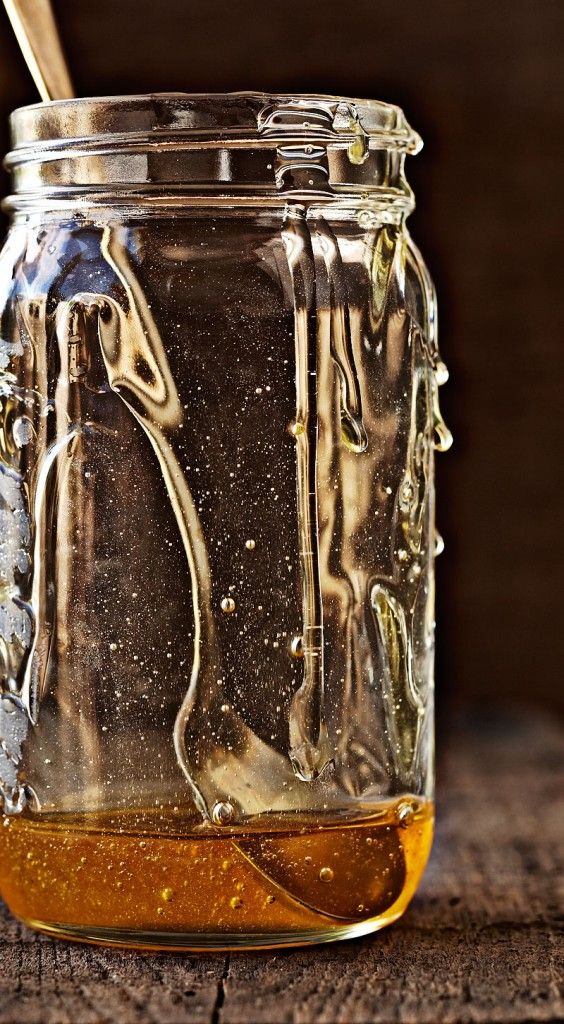 an empty jar with a spoon full of honey by crystalcartierphotography