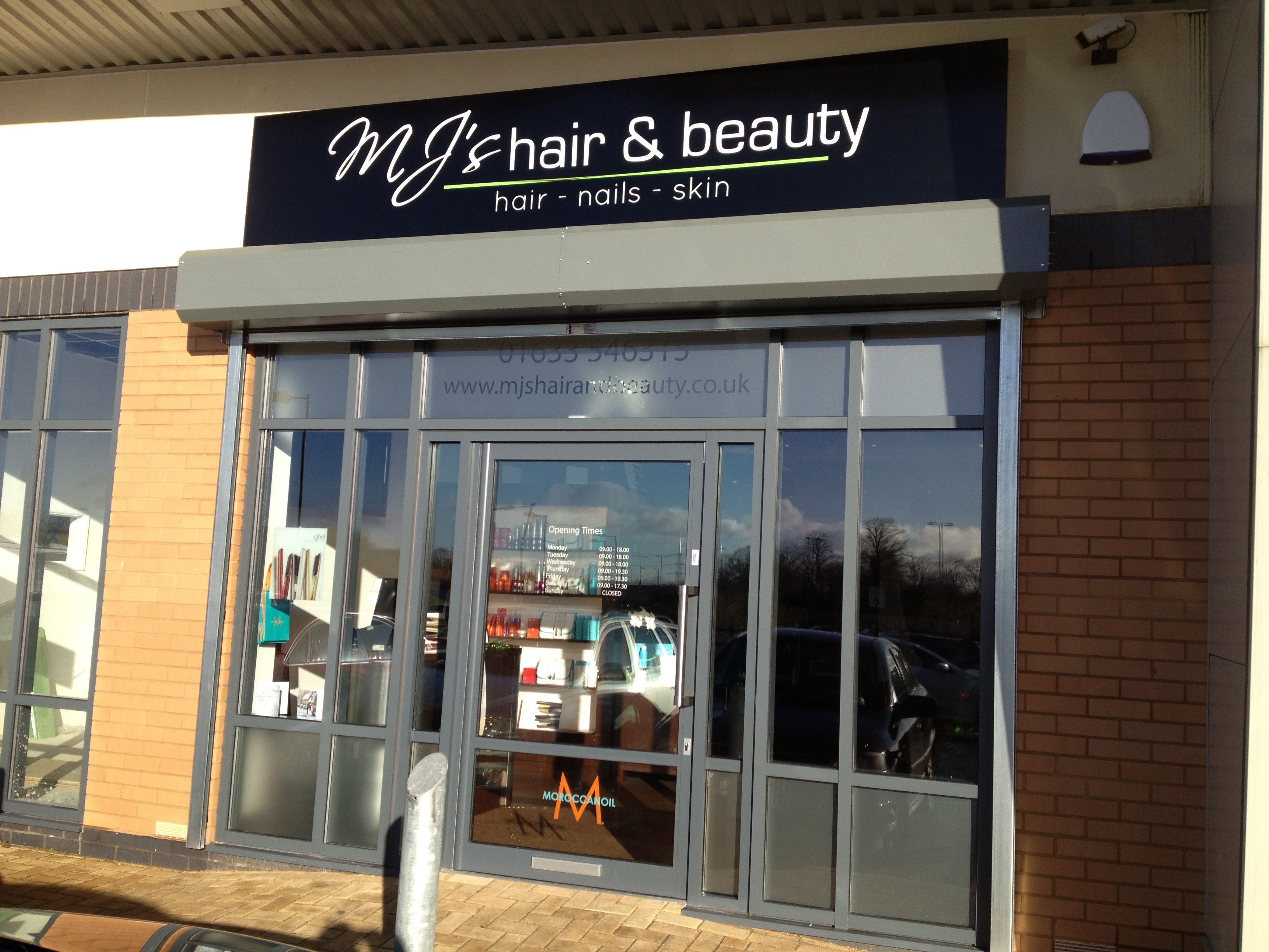 a hair and beauty store front with its reflection in the glass door