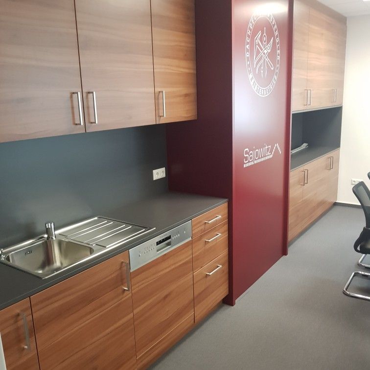 Kuche In Nussholz Im Modernen Look Mit Edelstahlfirmenlogo Auf