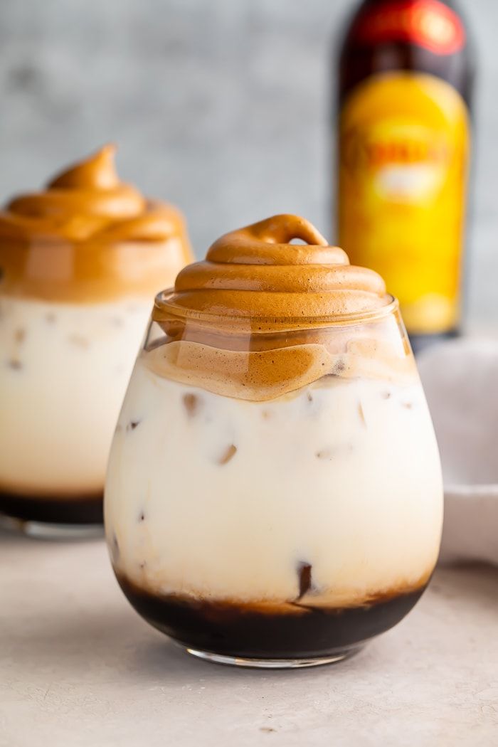 What's better than fluffy, sweet whipped coffee over milk? Boozy whipped coffee, of course! This easy cocktail pairs coffee liqueur with milk, all topped with a little cloud of whipped coffee for an Instagram-worthy drink. Perfect for brunch or after dinner, and easy to make vegan. #dalgonacoffee #whippedcoffee #whiterussian #alcohol Vegan Drinks, Cocktail Drinks Recipes, Coffee Cocktails, Alcohol Drink Recipes, Easy Cocktails, Yummy Drinks, Desserts With Alcohol, Coffee Mixology, Alcoholic Coffee Drinks