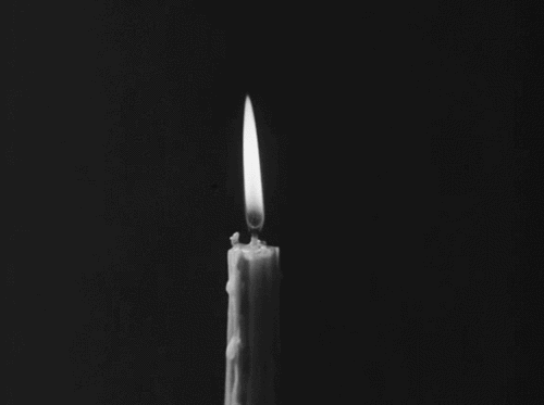 This may contain: a candle is lit in the dark with only one candle left on it's side