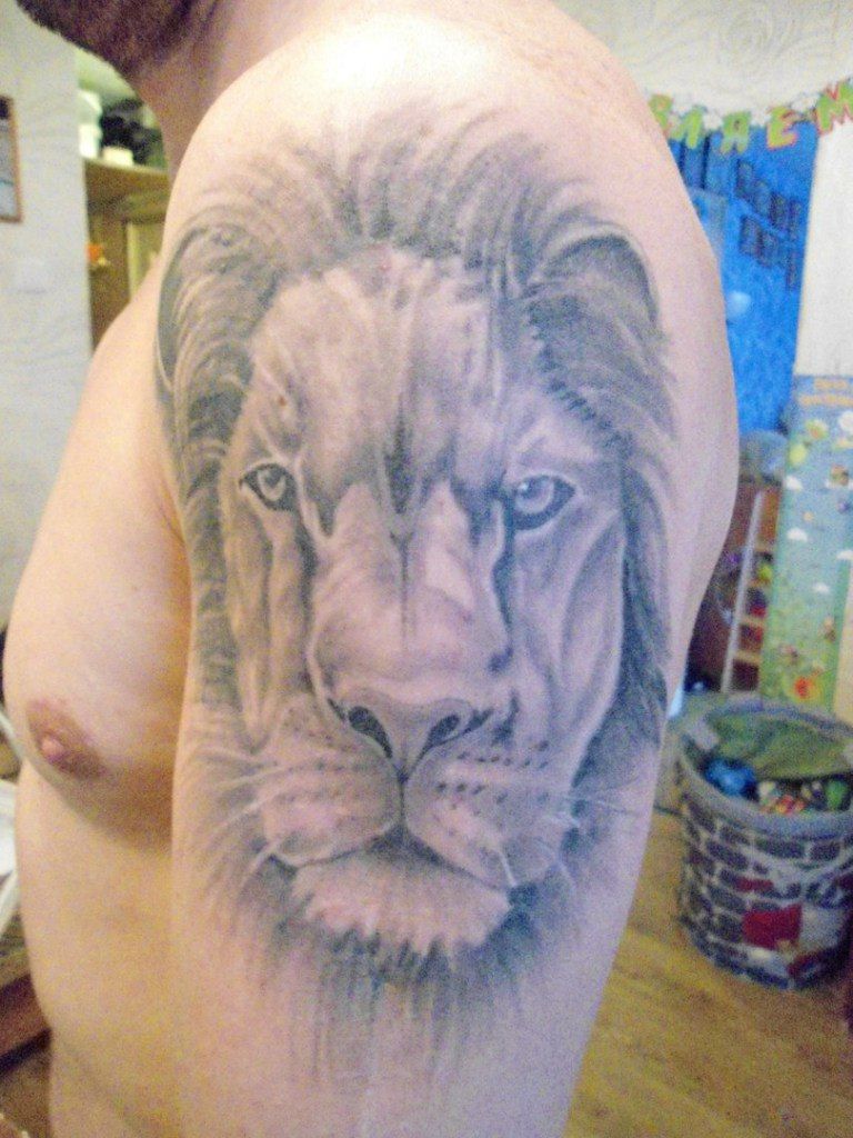 Lion tattoo on shoulder black and grey by Viktor Kitaec